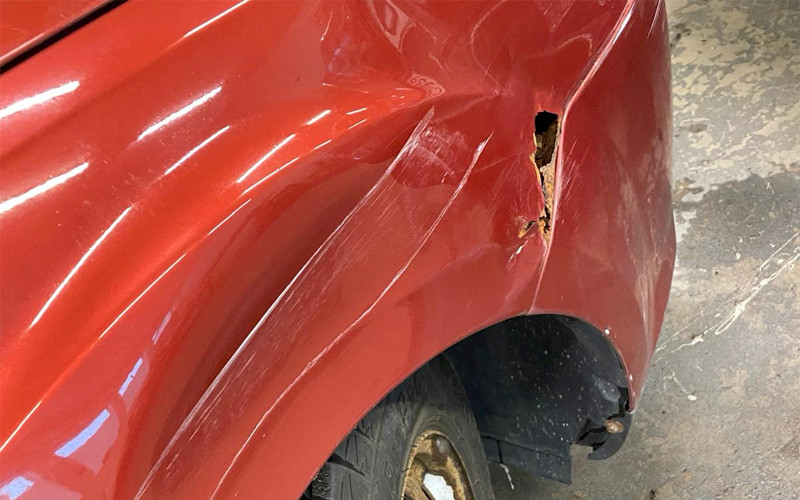 Kuva autosta jossa pelti ruostunut niin että siinä reikä